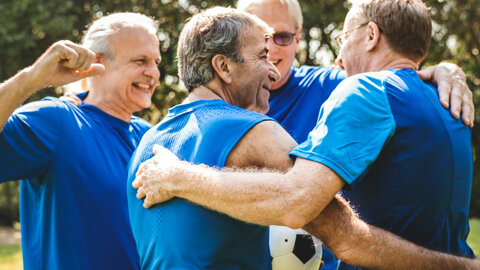 Runde an Männern die sich umarmen nach dem Sport