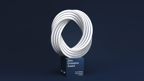 Drei Zero Emissions Award Pokale vor dunkelblauem Hintergrund
